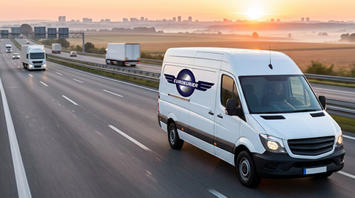 Weißer EUROKURIER Transporter auf Autobahn bei Sonnenuntergang.